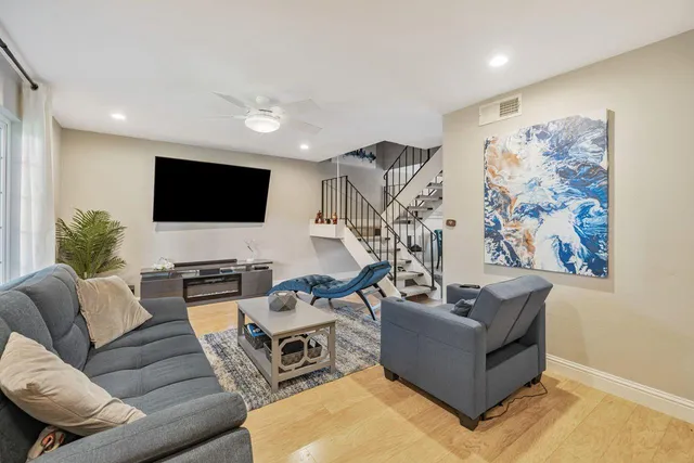 a kitchen with stainless steel appliances kitchen island a table chairs in it and wooden floors