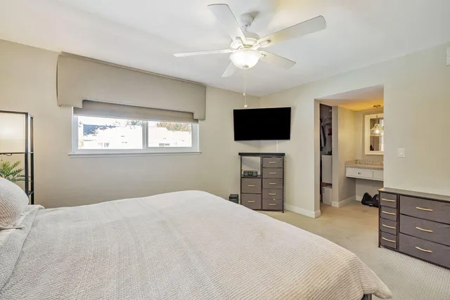 a spacious bedroom with a bed and a flat screen tv