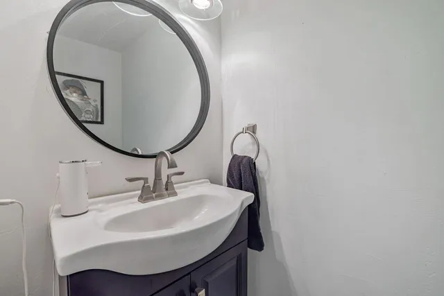 a bathroom with a granite countertop sink a toilet and shower