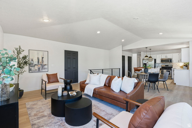2460 Allison Way Syracuse, UT 84075 - Photo 5 of 24 Spacious open-concept living area featuring vaulted ceilings, light wood-finish flooring, and recessed lighting