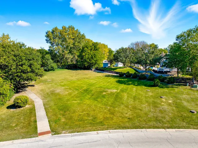 a view of swimming pool with lawn chairs and iron fence