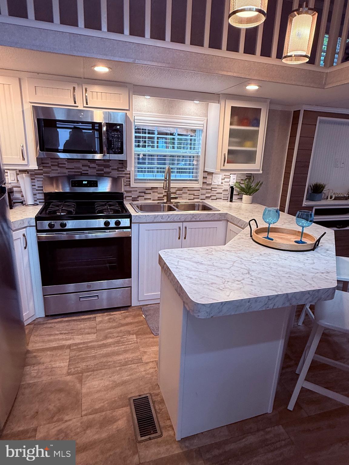 a kitchen with kitchen island granite countertop wooden cabinets a stove and a sink
