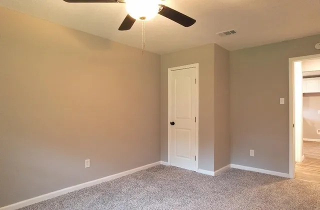 an empty room with a window and a fan