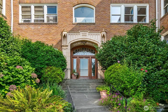a front view of a house with plants and garden