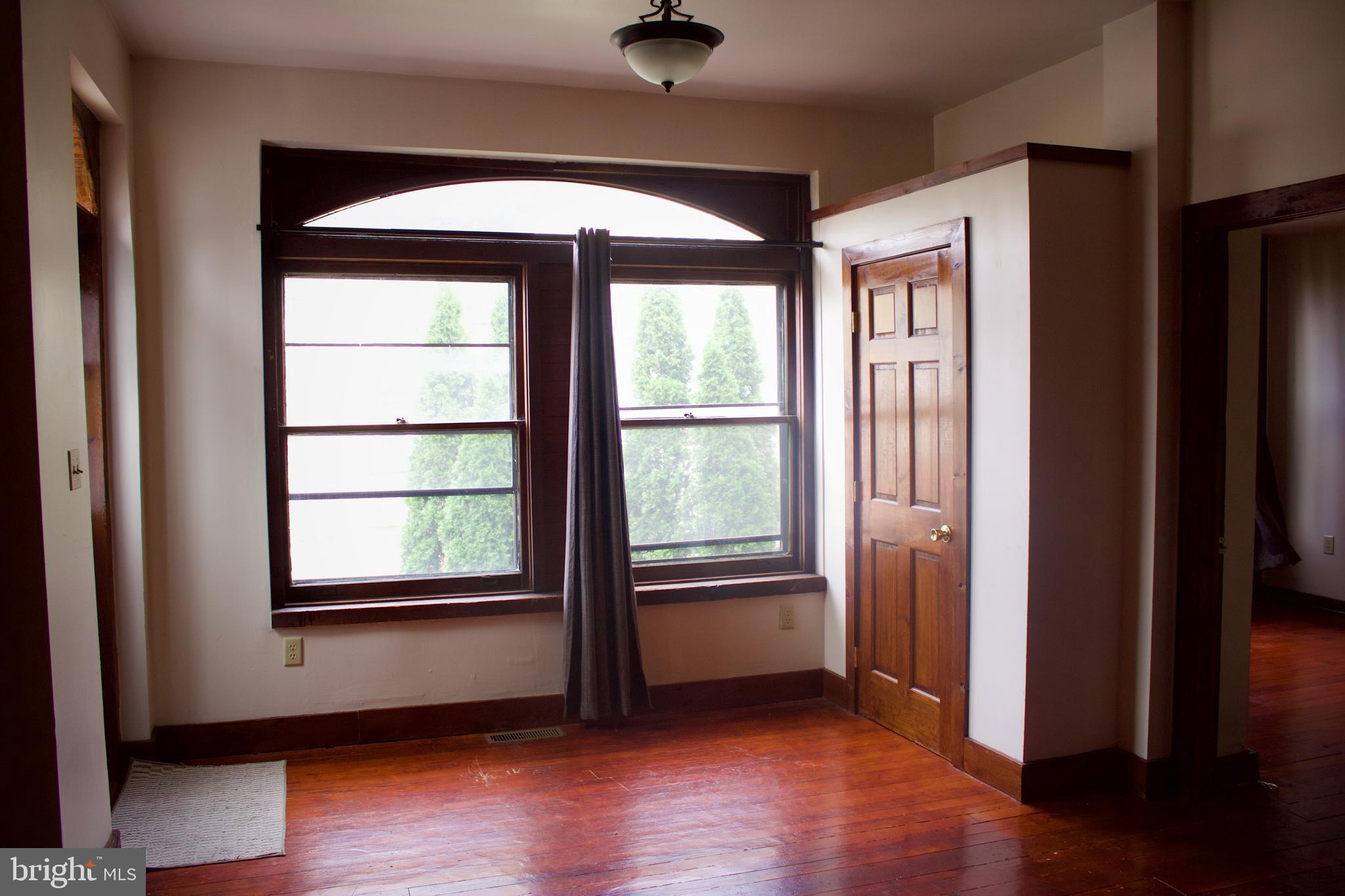 209 West Chestnut Street, Unit 2 West Chester, PA 19380 - Photo 3 of 23 a view of an empty room with wooden floor and a window