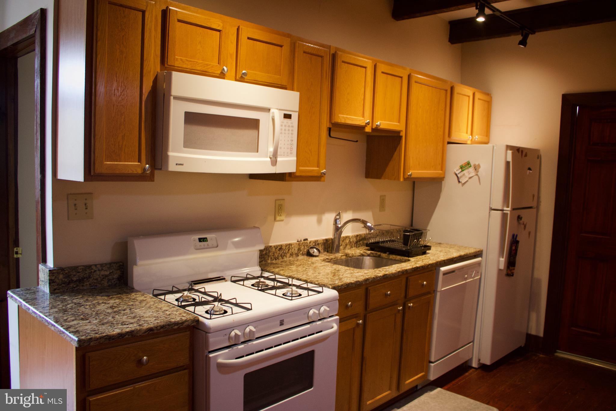 209 West Chestnut Street, Unit 2 West Chester, PA 19380 - Photo 6 of 23 a kitchen with stainless steel appliances granite countertop a stove a refrigerator and a microwave