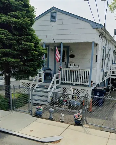 a view of a chair and table in backyard of the house