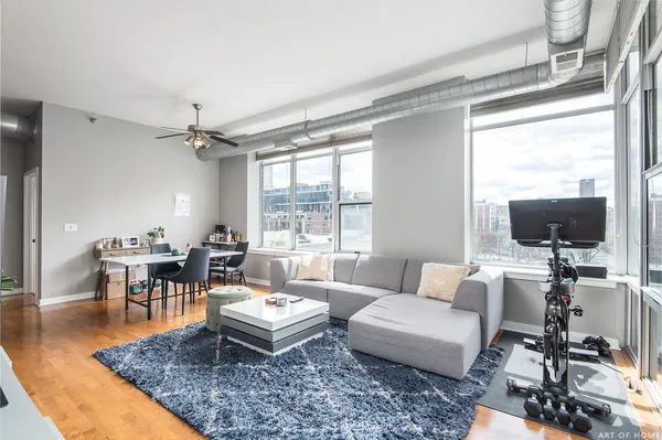 a living room with furniture a flat screen tv and a large window