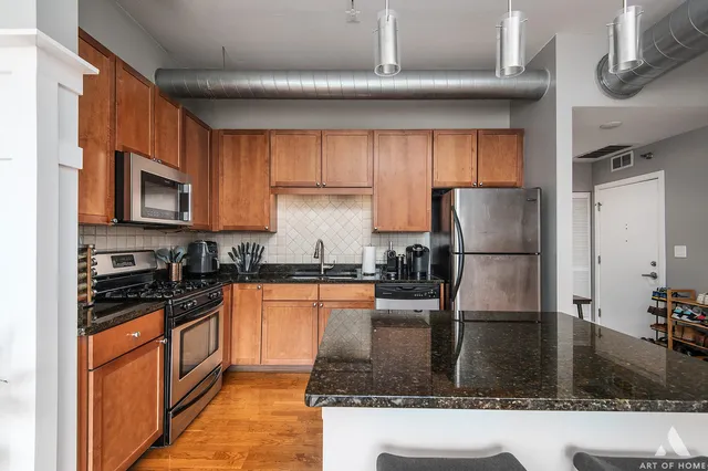 a kitchen with granite countertop a refrigerator a stove and a sink