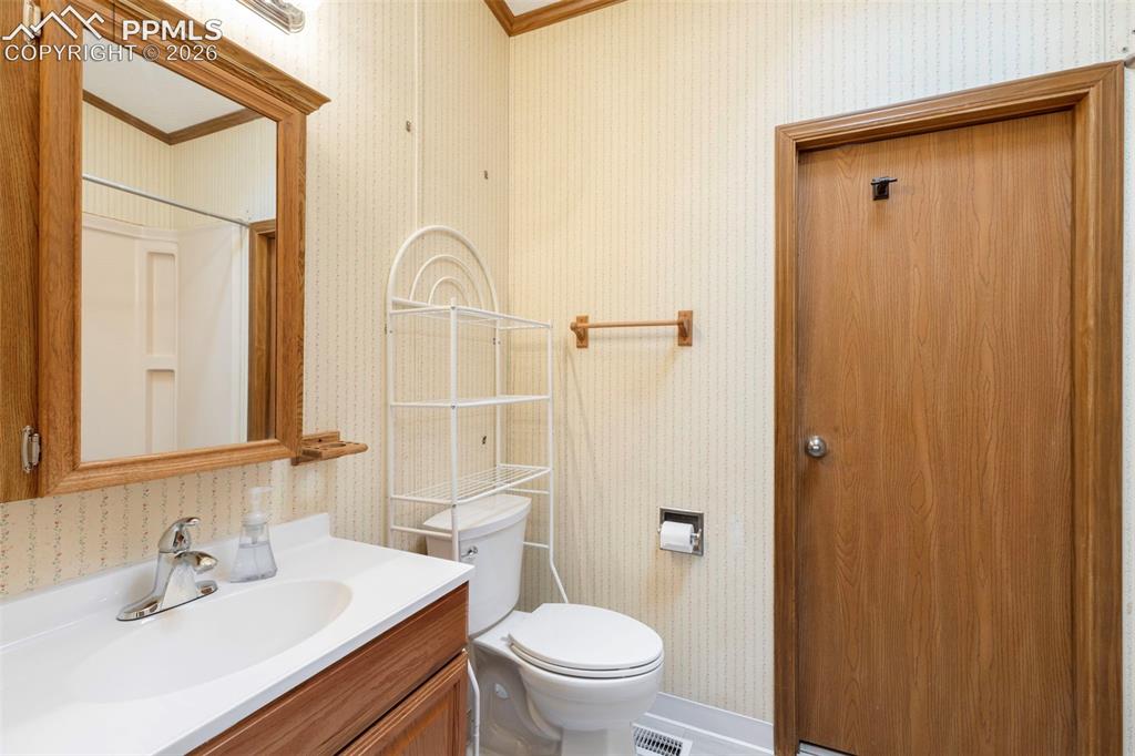 13335 Gymkhana Road Peyton, CO 80831 - Photo 25 of 38 Bathroom featuring a wood-finish vanity with an integrated sink and chrome faucet