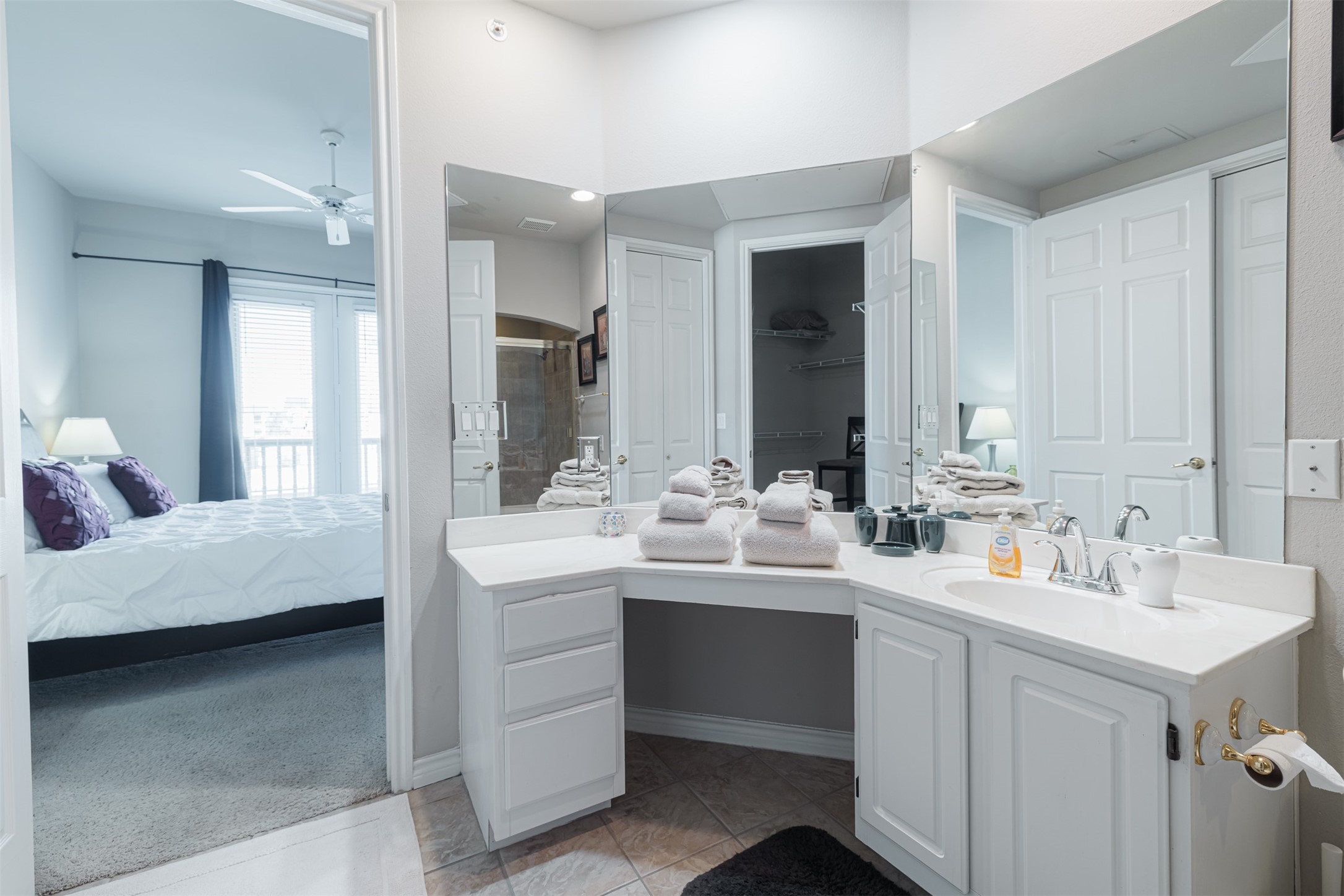 2400 McCue Road, Unit 248 Houston, TX 77056 - Photo 9 of 24 Elegant bathroom with a dual-sink vanity, ample storage, and a spacious mirror. Direct access to a cozy bedroom featuring large windows for natural light.