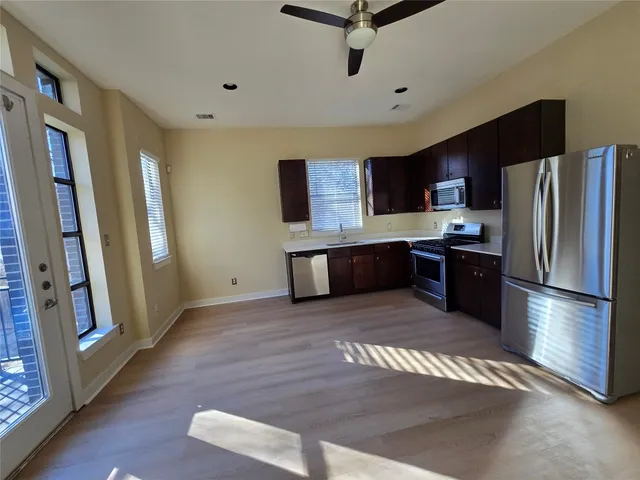 a kitchen with stainless steel appliances granite countertop a refrigerator sink and stove