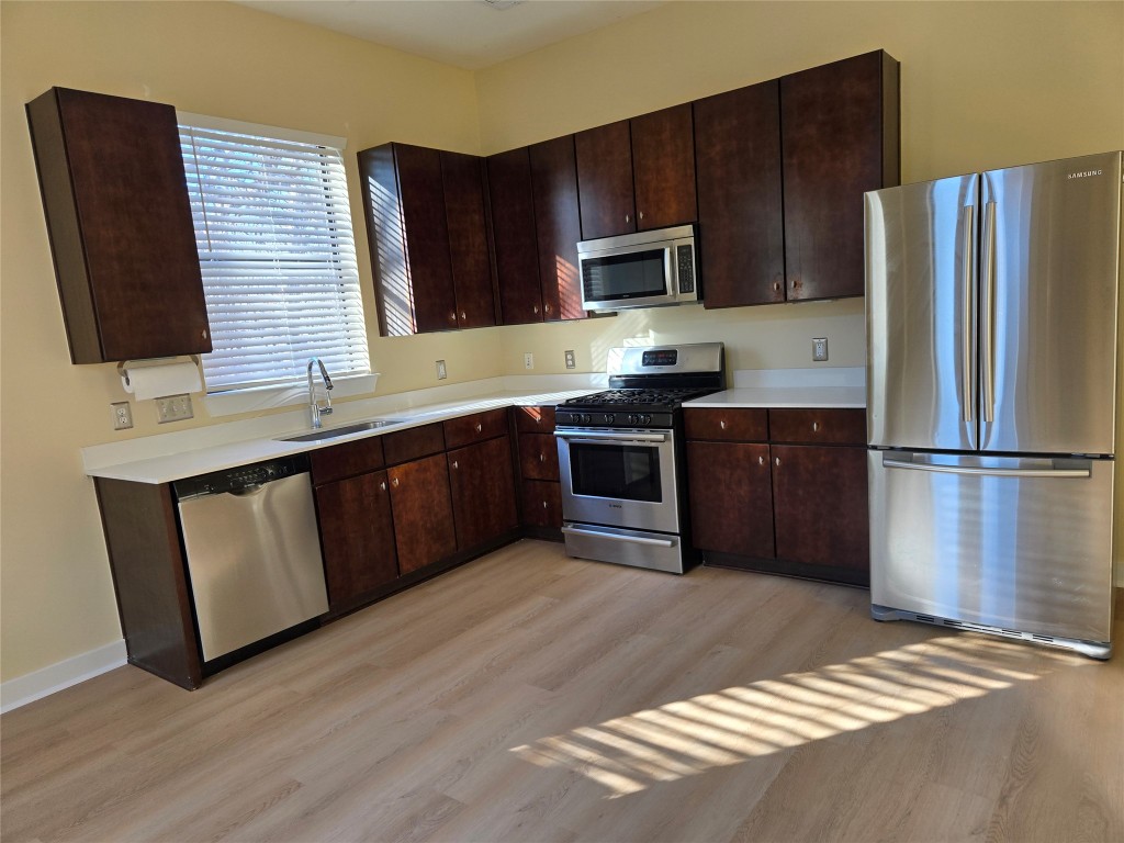 6000 South Congress Avenue, Unit 404 Austin, TX 78745 - Photo 14 of 23 a kitchen with stainless steel appliances granite countertop wooden cabinets a stove top oven a sink and dishwasher