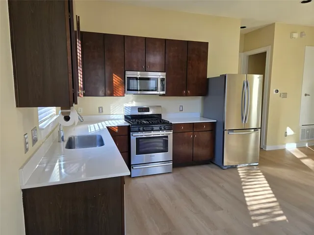 a kitchen with a sink a stove a refrigerator and cabinets
