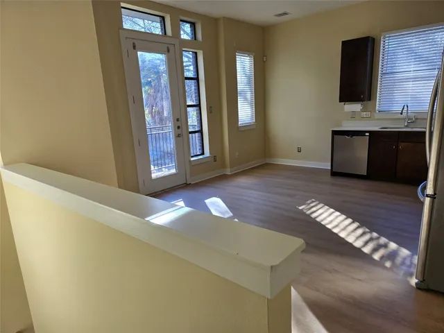 a view of an empty room with window and wooden floor