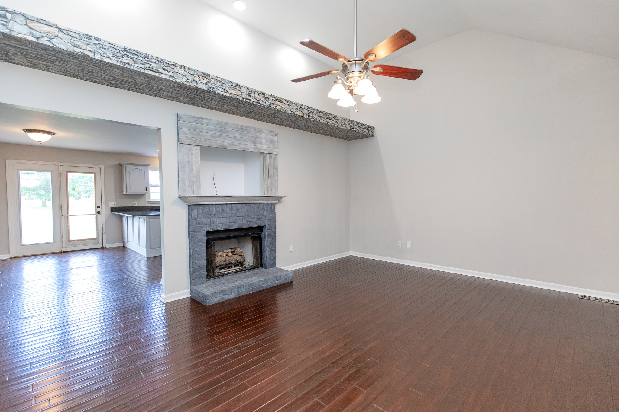 443 Clearview Road Cottontown, TN 37048 - Photo 3 of 21 an empty room with wooden floor fireplace and windows