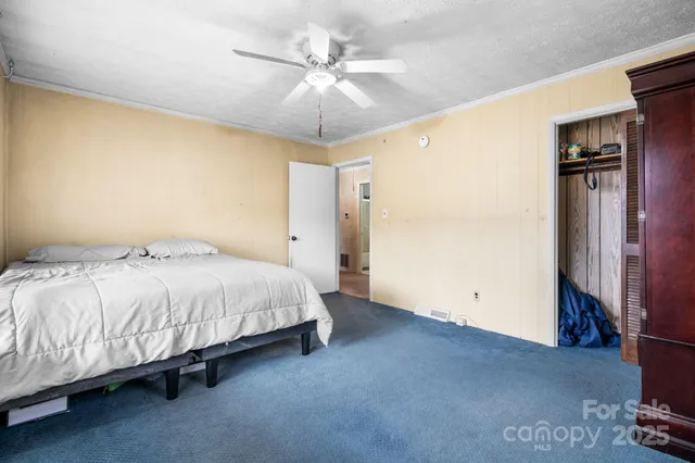 a spacious bedroom with a bed and a chandelier