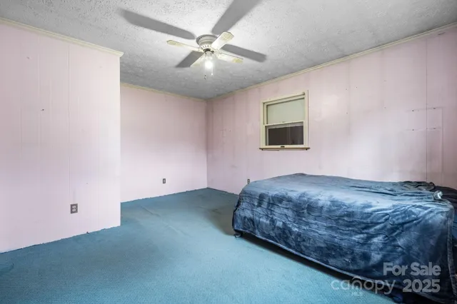 a bedroom with a bed and a chandelier fan