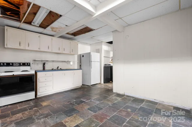 a view of a kitchen with refrigerator and cabinets