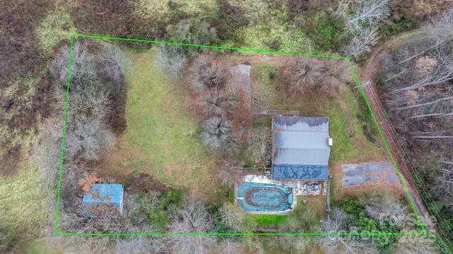 an aerial view of a house with a yard and a large tree