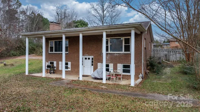 a view of a house with a yard and large tree