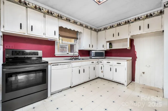 a kitchen with stainless steel appliances a white cabinets and a stove top oven