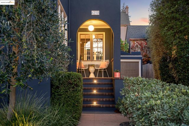 a view of a brick house with a large windows and a flower garden