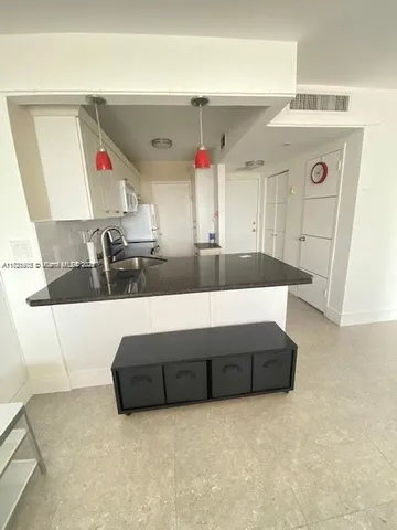 a living room with kitchen furniture and a fireplace