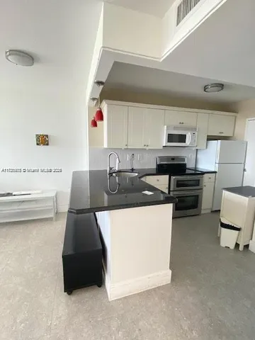 a kitchen with a sink a stove and cabinets