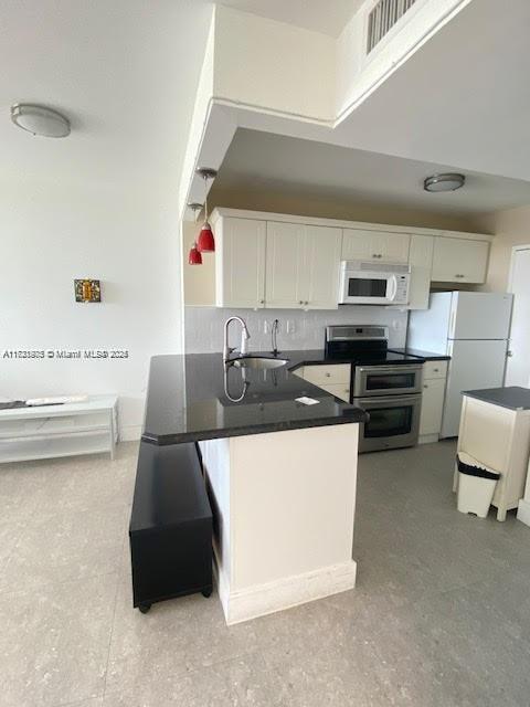 2899 Collins Avenue, Unit 548 Miami Beach, FL 33140 - Photo 6 of 22 a kitchen with a sink a stove and cabinets
