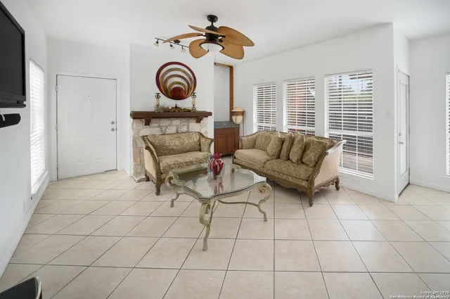 a living room with furniture a flat screen tv and kitchen view