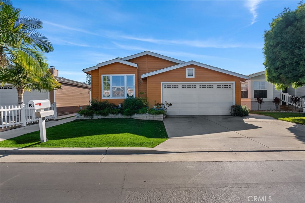 7271 Katella Avenue, Unit 101 Stanton, CA 90680 - Photo 1 of 34 a front view of a house with a garden and garage
