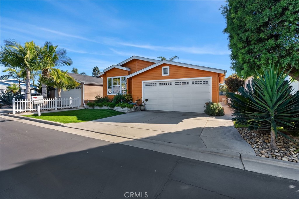 7271 Katella Avenue, Unit 101 Stanton, CA 90680 - Photo 21 of 34 a front view of a house with a yard and garage