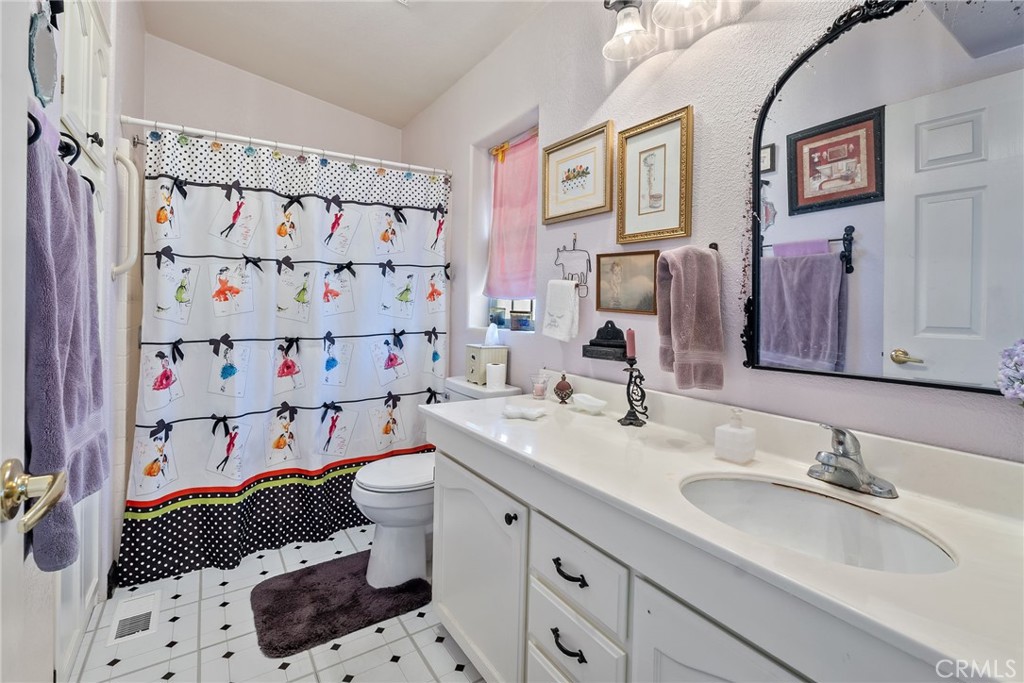 7271 Katella Avenue, Unit 101 Stanton, CA 90680 - Photo 25 of 34 a bathroom with a sink a toilet and shower curtain