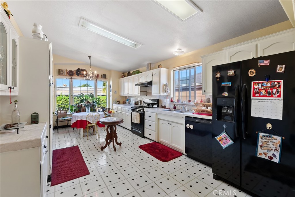 7271 Katella Avenue, Unit 101 Stanton, CA 90680 - Photo 27 of 34 a kitchen with stainless steel appliances kitchen island granite countertop a refrigerator sink and cabinets