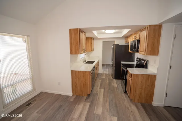 a view of a kitchen with fridge and wooden floor