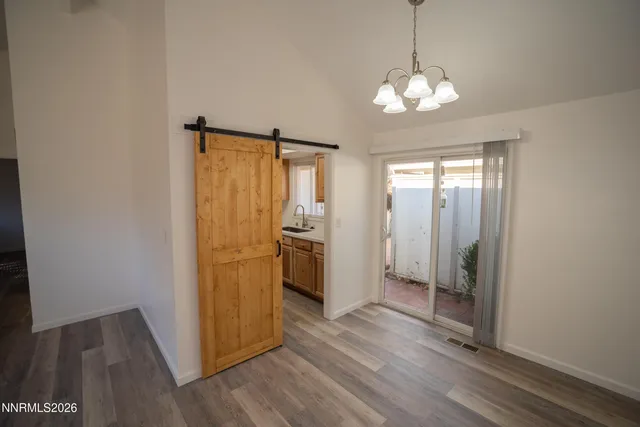 a view of a hallway with wooden floor and a kitchen