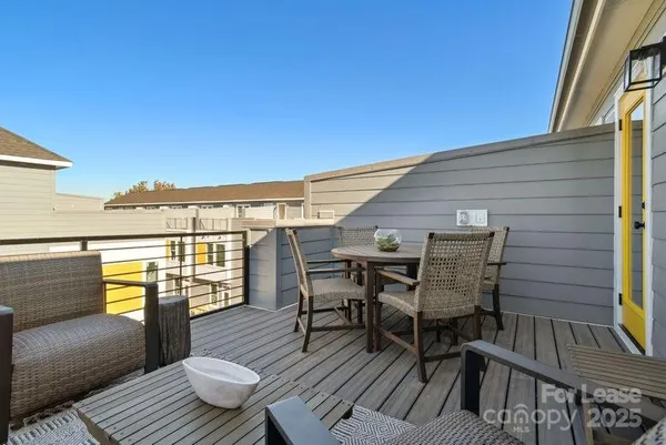 a view of a balcony with wooden floor and outdoor seating