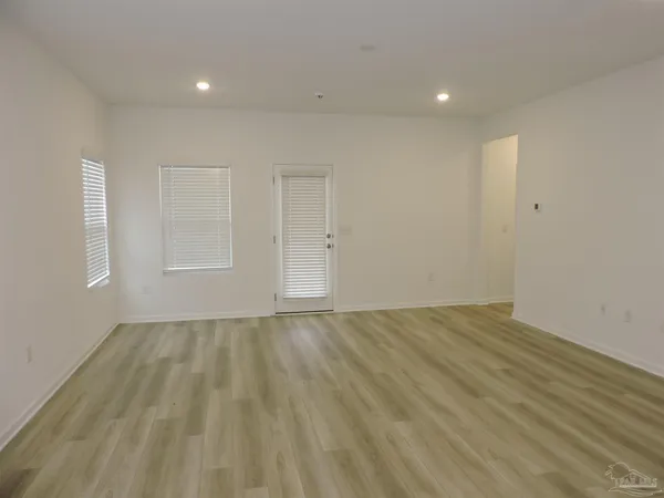 a view of an empty room with wooden floor