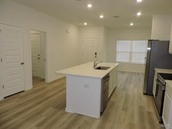 a kitchen with a sink and wooden floor