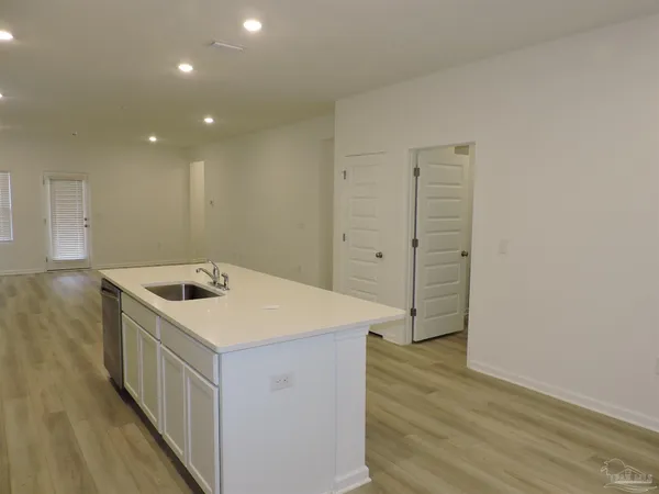 a kitchen with a wooden floor and cabinets
