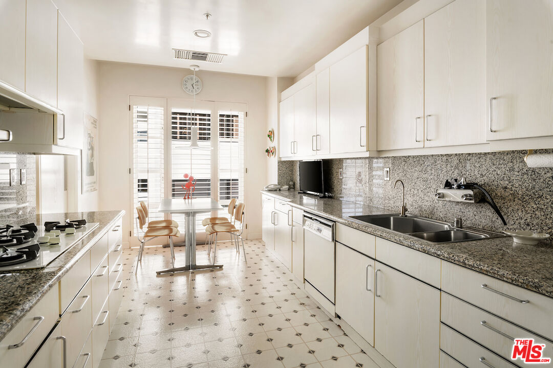 10580 Wilshire Boulevard, Unit 45 Los Angeles, CA 90024 - Photo 17 of 35 a kitchen with stainless steel appliances a stove a sink and white cabinets