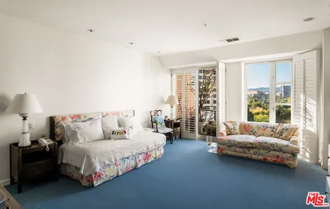 a spacious bedroom with a bed couch and a large window