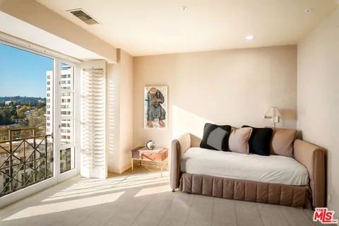 a bedroom with a bed and a large window