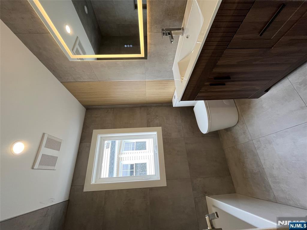 17 Market Street, Unit 2 Garfield, NJ 07026 - Photo 11 of 16 a bathroom with a toilet sink and mirror