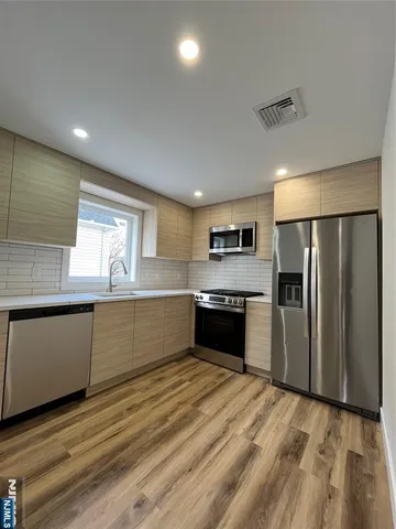 a large kitchen with granite countertop a refrigerator and a stove top oven