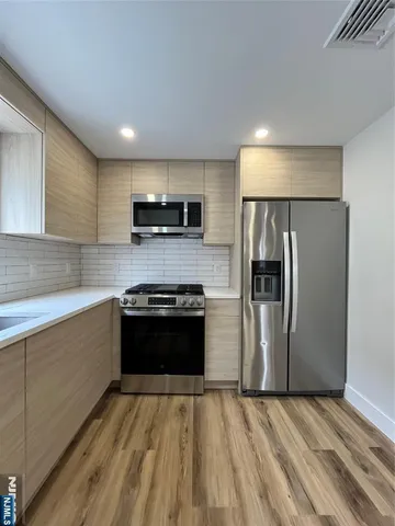 a kitchen with kitchen island a refrigerator and a stove top oven