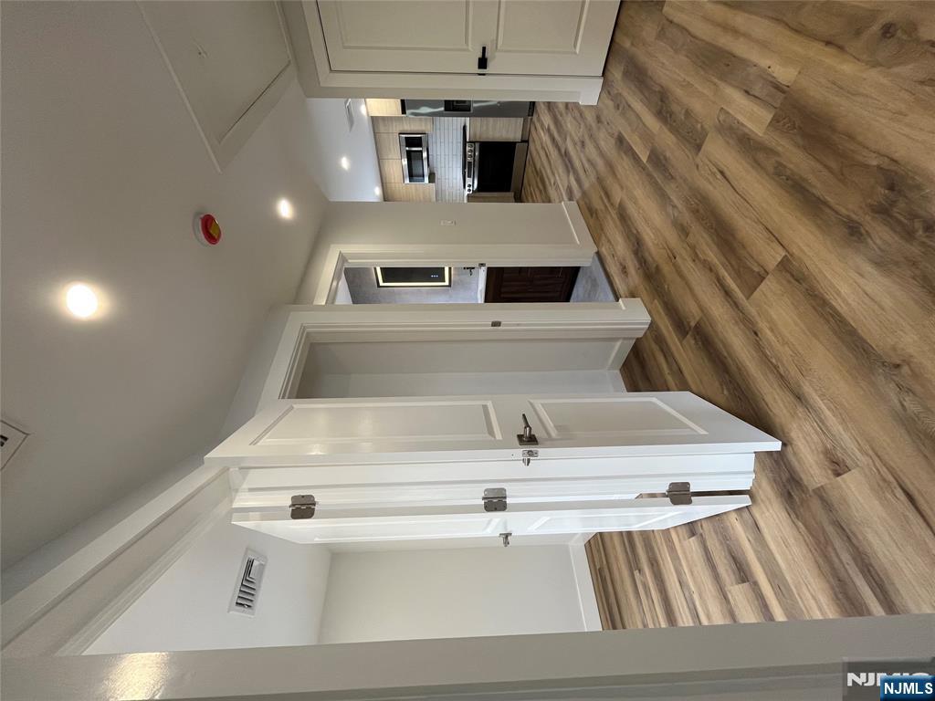 17 Market Street, Unit 2 Garfield, NJ 07026 - Photo 10 of 16 a view of a hallway with wooden floor and a bathroom