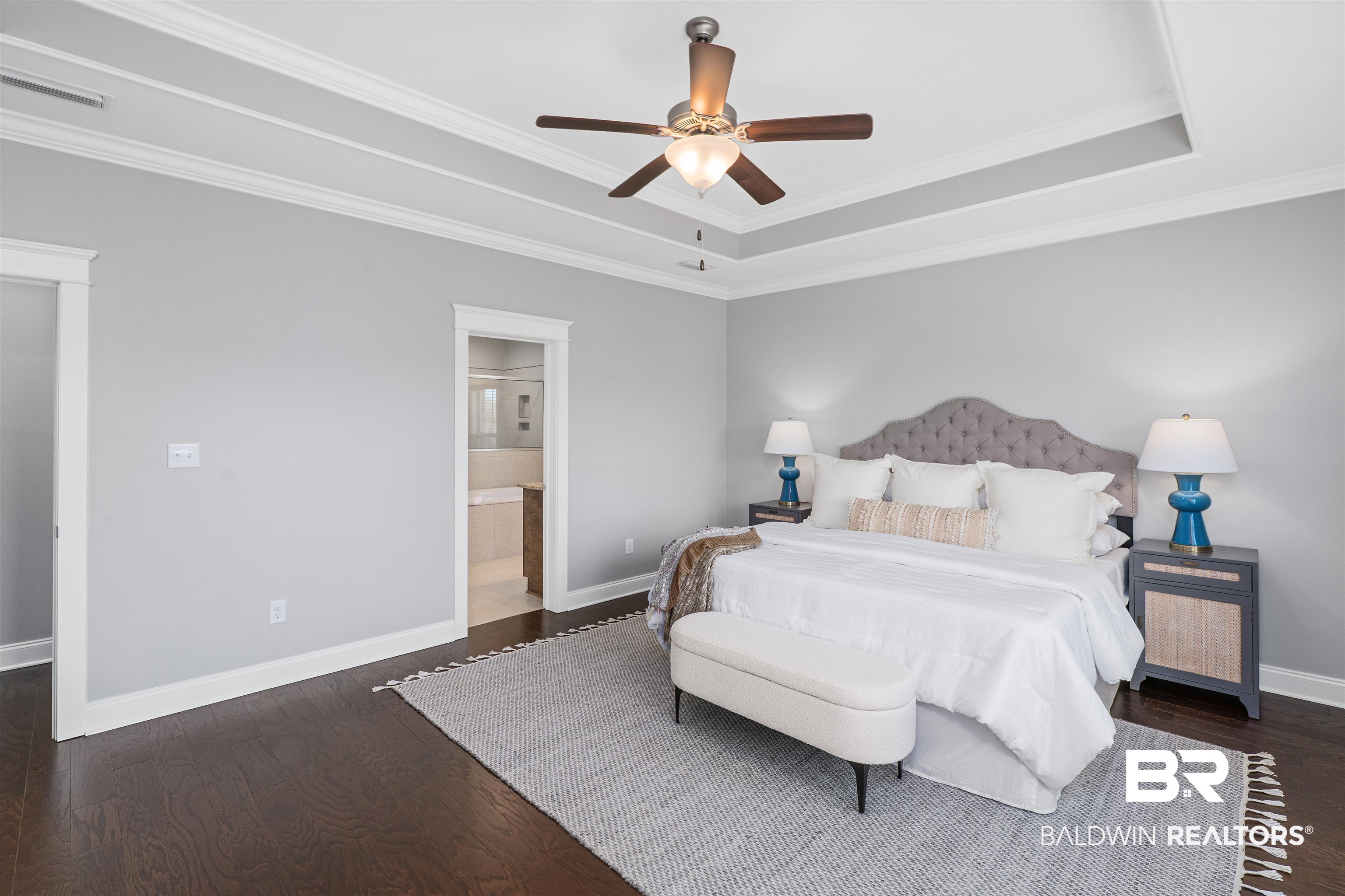 24838 Slater Mill Road Daphne, AL 36526 - Photo 32 of 46 Bedroom featuring ornamental molding, dark wood-style flooring, a tray ceiling, ensuite bathroom, and a ceiling fan