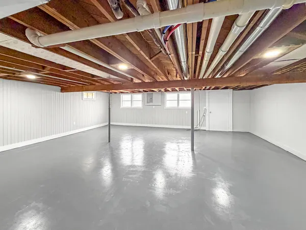a view of an empty room with wooden floor and a fireplace